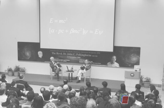 Figure 8. Polkinghorne and Yang engaged in an East-West dialogue on science and religion. Einstein’s and Dirac’s equations appear on the projected screen. Credit: Centre for Sino-Christian Studies, Hong Kong Baptist University.